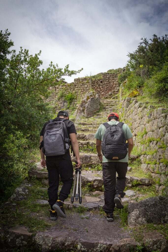 Ángel y Cristian, fundadores de Qosqo Trips, subiendo juntos una escalinata inca de piedra
